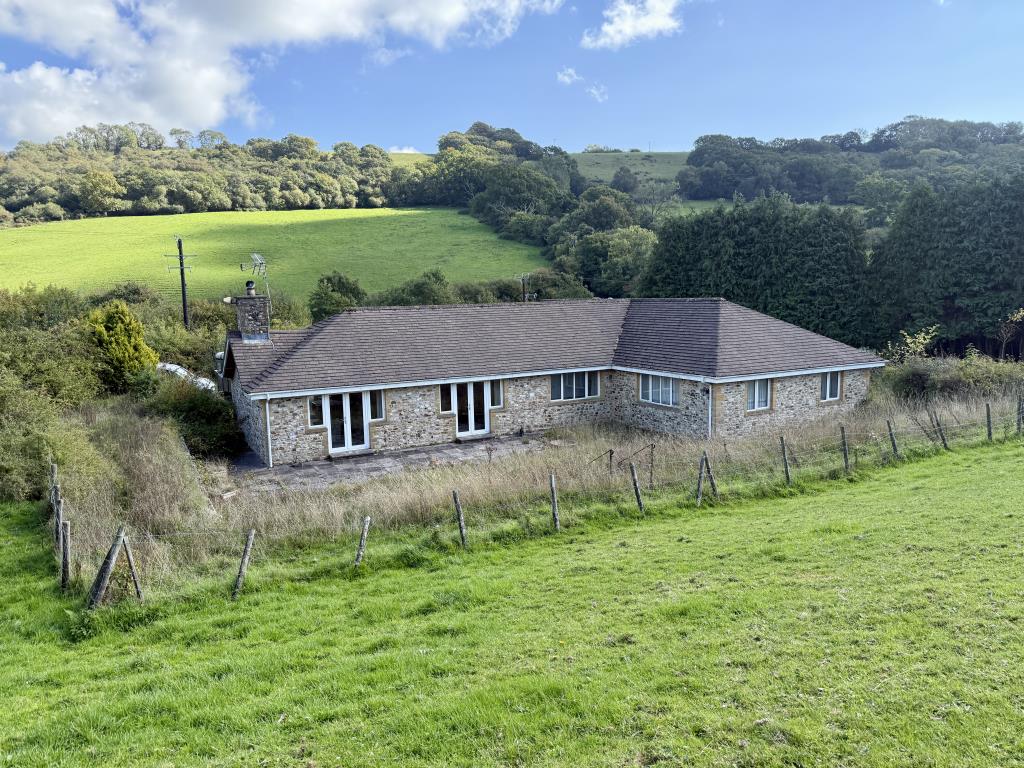 Lot: 26 - SMALL HOLDING OF APPROXIMATELY 86 ACRES OF PASTURE AND WOODLAND, DETACHED BUNGALOW PLUS TWO AGRICULTURAL BARNS - View of the rear of the bungalow